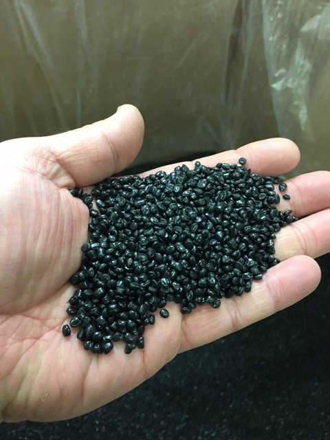 person holding a handful of thermoplastic resin